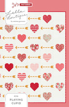 Load image into Gallery viewer, "Playing Cupid" valentines quilt featuring patchwork hearts and golden arrows. Make it with a Layer Cake or fat eighths. Fabric is Love Blooms by Lella Boutique for Moda Fabrics. (Nov 2024)