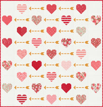 Load image into Gallery viewer, "Playing Cupid" valentines quilt featuring patchwork hearts and golden arrows. Make it with a Layer Cake or fat eighths. Fabric is Love Blooms by Lella Boutique for Moda Fabrics. (Nov 2024)