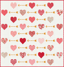Load image into Gallery viewer, "Playing Cupid" valentines quilt featuring patchwork hearts and golden arrows. Make it with a Layer Cake or fat eighths. Fabric is Love Blooms by Lella Boutique for Moda Fabrics. (Nov 2024)