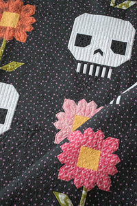 "Pushing Up Daisies" skull quilt by Lella Boutique. Cute mix of daisies and skeletons in this Halloween quilt. Fabric is Hey Boo by Lella Boutique for Moda Fabrics (April 2024).