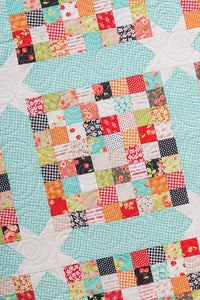 Scrap Happy scrappy square quilt from the book: Charm School - 18 Quilts from 5" Squares by Vanessa Goertzen of Lella Boutique. Get your autographed copy of the book here! Lots of great charm pack quilts. Fabric is Farmhouse by Fig Tree for Moda Fabrics.
