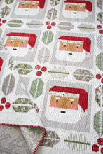 Load image into Gallery viewer, St. Nick Santa quilt by Vanessa Goertzen of Lella Boutique. Traditionally pieced Santa block framed with holly and berry quilt blocks. Make it with a Jelly Roll or Layer Cake. Fabric is Christmas Eve by Lella Boutique for Moda Fabrics.