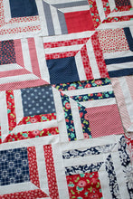 Load image into Gallery viewer, "Fracture" modern log cabin quilt. Fat eighth quilt. Great 4th of July quilt. Fabric is red and navy prints by Bonnie & Camille for Moda. Download the PDF here!
