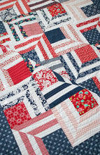 Load image into Gallery viewer, "Fracture" modern log cabin quilt. Fat eighth quilt. Great 4th of July quilt. Fabric is  red and navy prints by Bonnie & Camille for Moda.