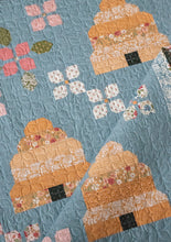 Load image into Gallery viewer, &quot;Bloom &amp; Buzz&quot; beehive and flower quilt y Lella Boutique. This charming little patchwork garden is Jelly Roll friendly and features Wild Honey fabric by Lella Boutique for Moda Fabrics (Nov 2025).