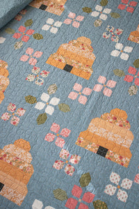Bloom & Buzz beehive and flower quilt by Lella Boutique. Jelly Roll friendly Fabric is Wild Honey by Lella Boutique for Moda Fabrics (Nov 2025).