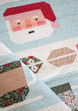 Load image into Gallery viewer, "Cocoa Party" Christmas row quilt featuring patchwork Santa, peppermint swirls, cocoa mugs, marshmallows, and holly and berry sashing. This Christmas sampler quilt is made with fat eighths of Peppermint Cocoa fabric by Lella Boutique for Moda Fabrics. Download the PDF here!