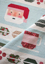 Load image into Gallery viewer, "Cocoa Party" Christmas row quilt featuring patchwork Santa, peppermint swirls, cocoa mugs, marshmallows, and holly and berry sashing. This Christmas sampler quilt is made with fat eighths of Peppermint Cocoa fabric by Lella Boutique for Moda Fabrics. Download the PDF here!