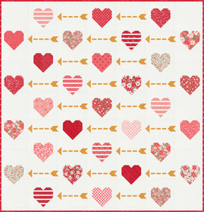 "Playing Cupid" valentines quilt featuring patchwork hearts and golden arrows. Make it with a Layer Cake or fat eighths. Fabric is Love Blooms by Lella Boutique for Moda Fabrics. (Nov 2024)
