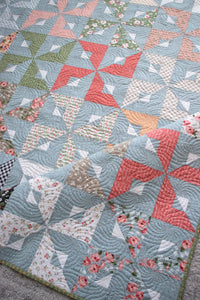 Busybody pinwheel quilt pattern by Lella Boutique. Make it with 1 Jelly Roll or 1 Layer Cake. Fabric is Country Rose by Lella Boutique for Moda Fabrics. Beginner friendly!