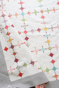 Diamond Dust diamond quilt in Lollipop Garden fabric by Lella Boutique. Make it with charm packs, mini charm packs, or scraps. Download the pattern here!