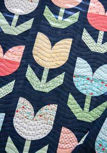 "Holland" tulip quilt by Lella Boutique. Beginner curved piecing technique to make simple tulip blocks. Fabric is Garden Variety by Lella Boutique for Moda. Download the PDF here!