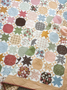 Starstruck 2 bursting star quilt featuring sawtooth star blocks. Layer Cake quilt or fat quarter quilt. Fabric is Folktale by Lella Boutique for Moda. Download the PDF here!